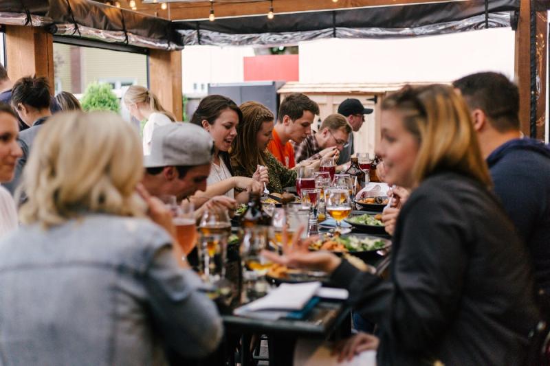 A group of independent workers gathered around a table,
  talking and sharing ideas