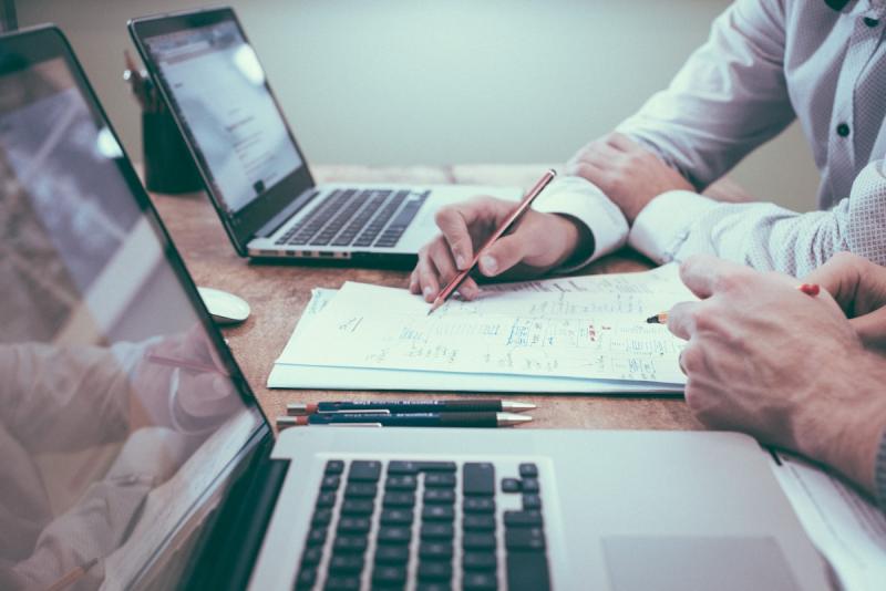 Professional creating a streamlined business plan with a laptop and notebook